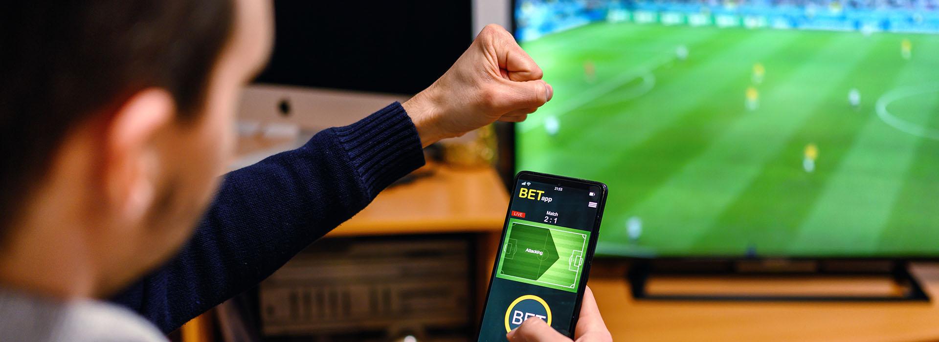 Person betting on sports with phone app