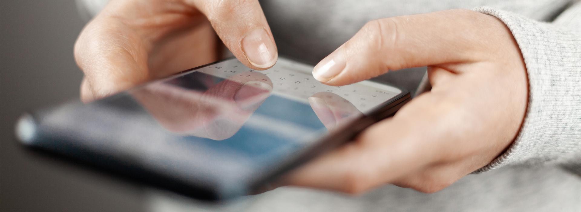 Hands of a person making transaction on cell phone
