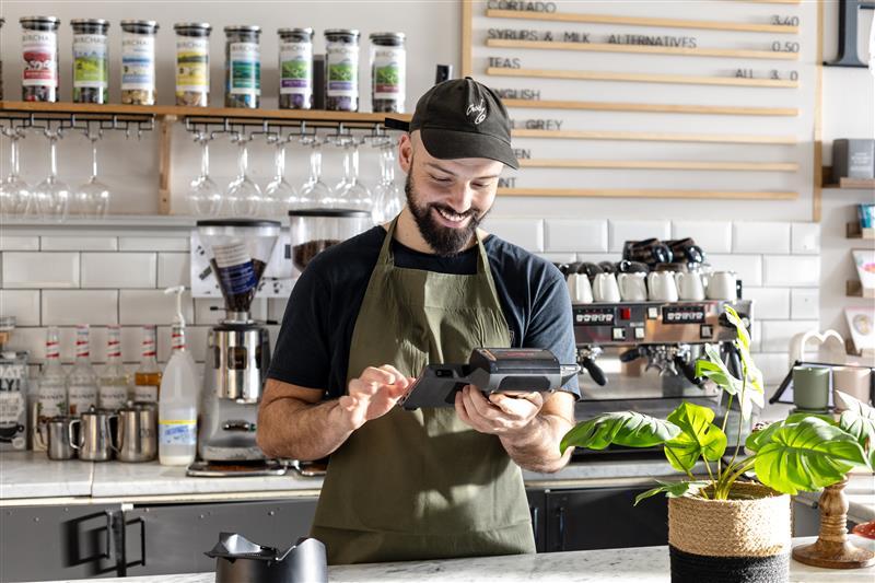 Person behind counter using card machine