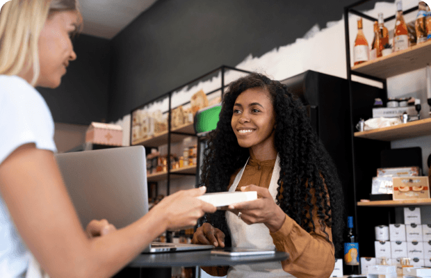 Woman handing cashier product she intends to purchase