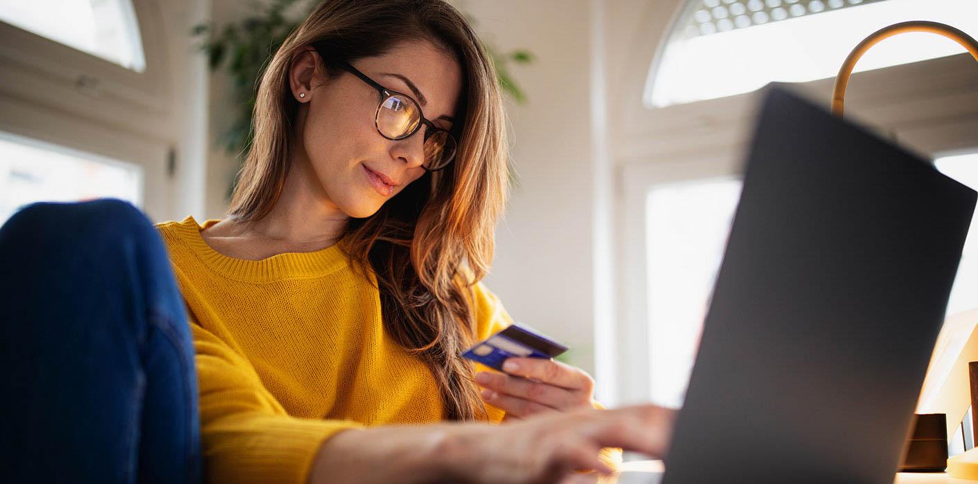 lady looking at her credit card in front of computer