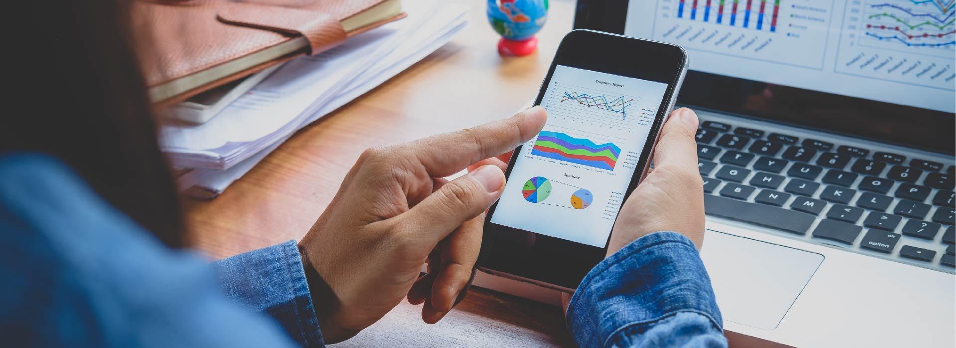 Woman holding mobile phone with a chart visible