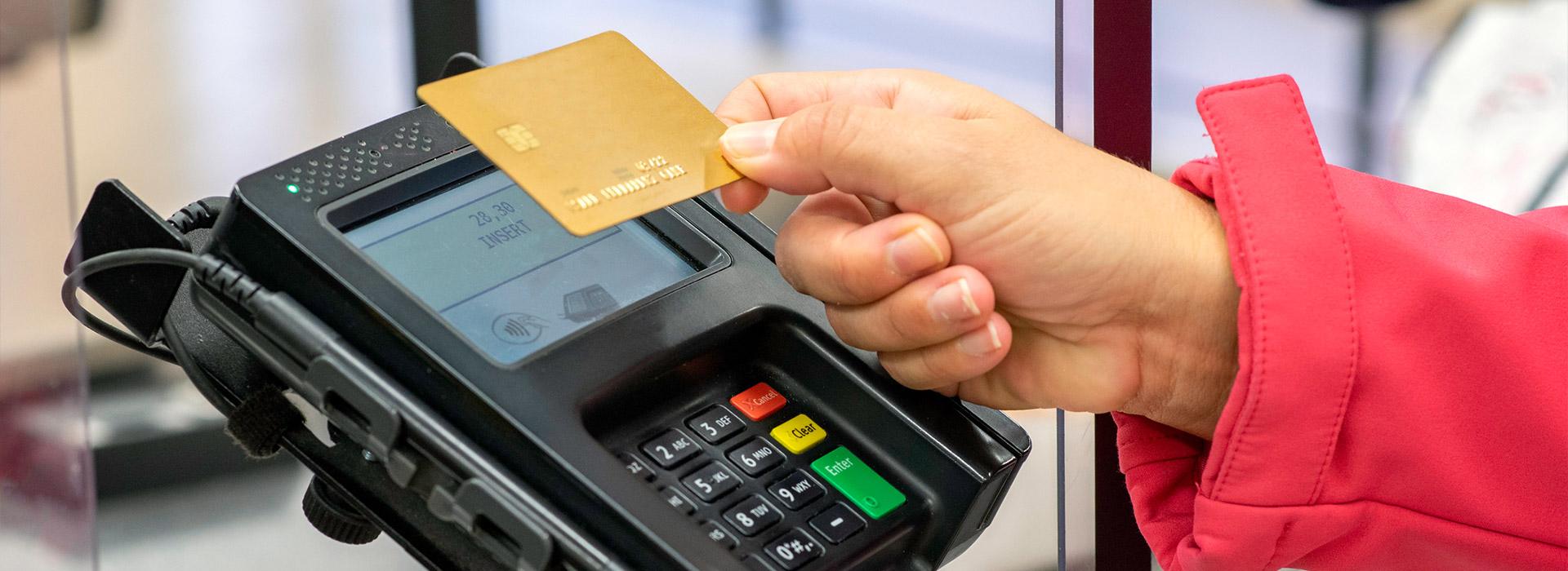 hand holding credit card at payment terminal